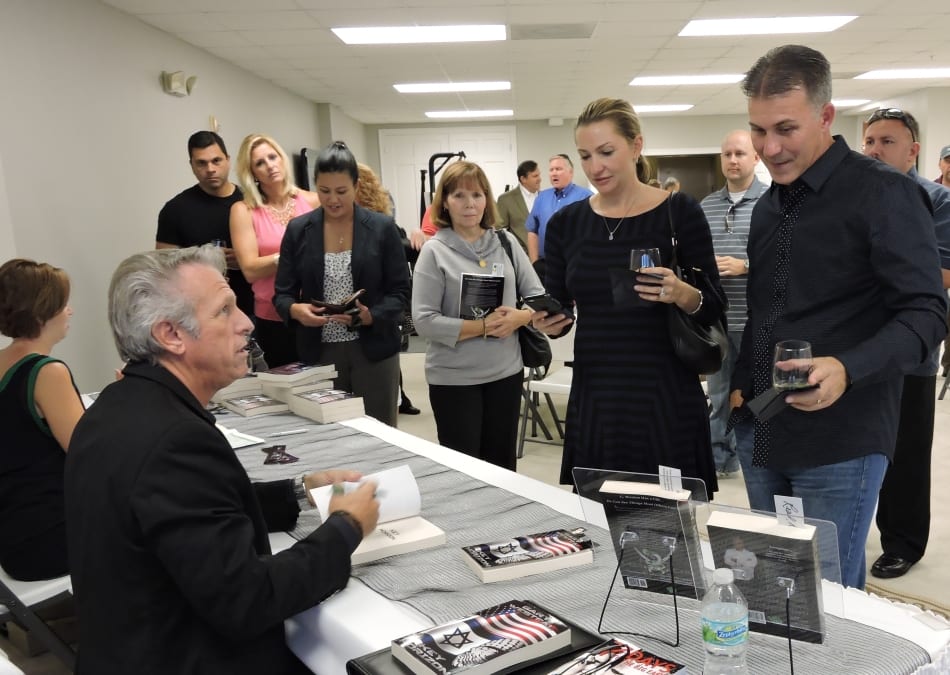 Gary signing books at a book launch. People lined up to get their book.