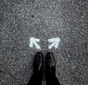 Feet, firmly planted on the pavement with two arrows, one pointing to the right and the other to the left.