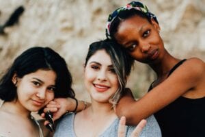 Three women of color whom appear to be friends.