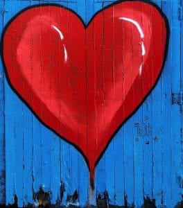 A heart painting on a wooden fence