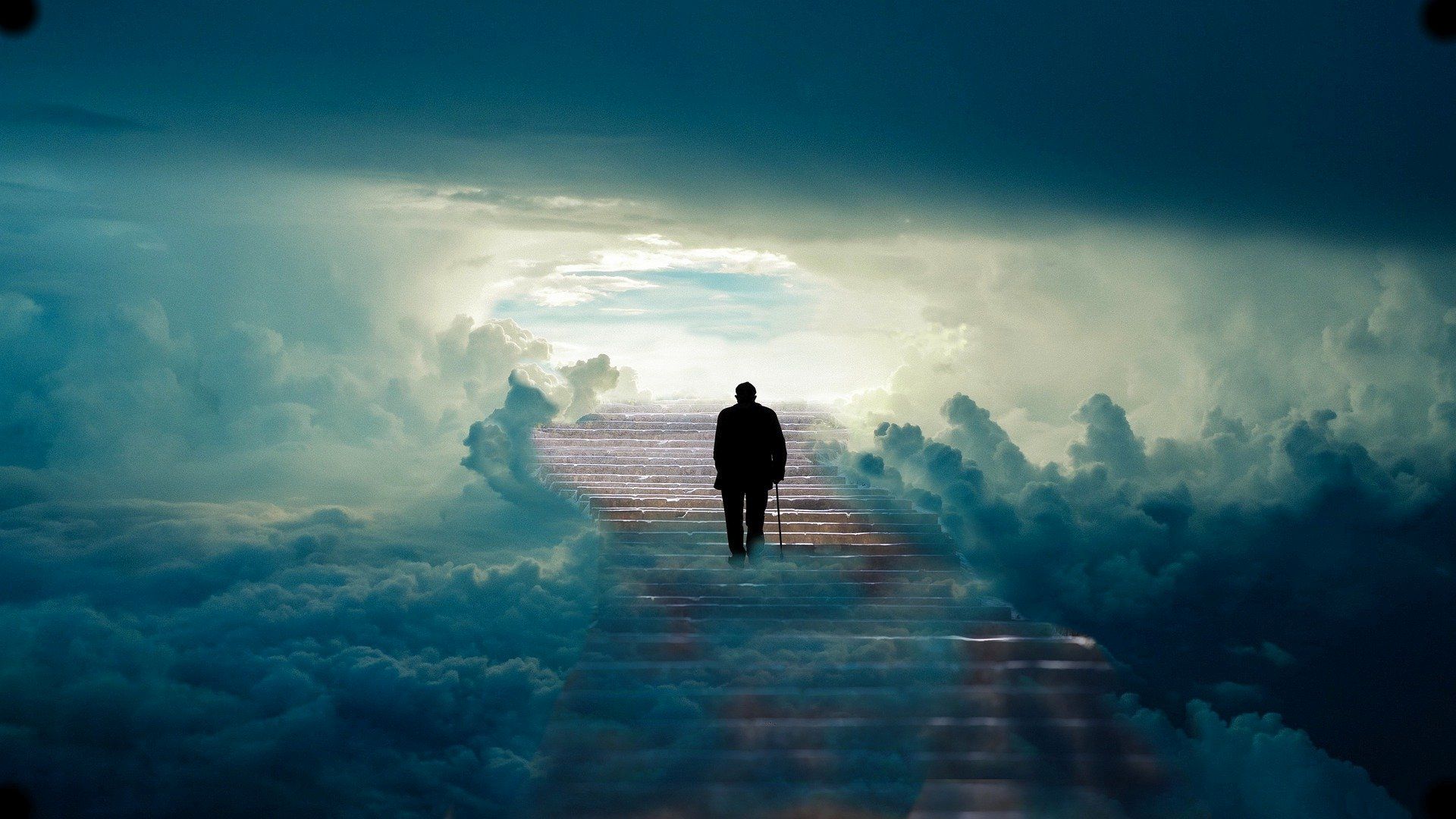 Silhouette of a man walking on a path through the clouds